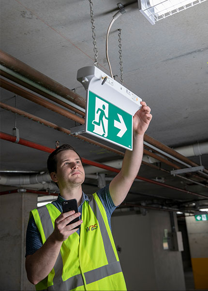 EMIoT Exit Sign being installed and commissioned by the WBS Technology Team